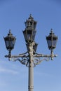 Classic black metallic candelabra street light lamppost with five lamps close up on a blue sky background Royalty Free Stock Photo