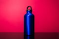 Classic blue of aluminum thermo eco water bottle isolated on pink coral background.