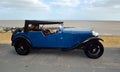 Classic Blue Alvis Motor car parked on seafront promenade.