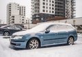 Classic blue car Saab Aero covered with snow during snowfall in harsh winter