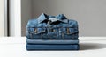 Classic blue denim jacket and jeans folded in a neat stack on a white surface Royalty Free Stock Photo