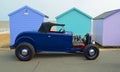 Classic Blue Hot rod parked in front of beach huts on seafront promenade. Royalty Free Stock Photo