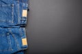 Classic blue jeans. Casual pants clothing blue jeans with brown blank leather labels on black background with copy space