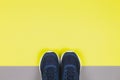 Classic blue sneakers on the yellow and grey background. Concept for healthy lifestyle and everyday training