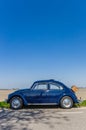 Classic blue Volkswagen beetle on a country road