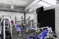 A classic bright gym. White sport equipment and blue seats and black board.