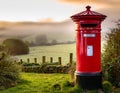 Classic British Red Post Box with a misty countryside backdrop Royalty Free Stock Photo