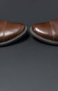 Classic brown leather men`s shoes on gray black background top view flat lay with copy space. Fashion male concept, genuine Royalty Free Stock Photo