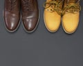 Classic brown leather men`s shoes and Yellow men`s work boots from natural nubuck on gray black background top view flat lay cop Royalty Free Stock Photo