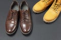 Classic brown leather men`s shoes and Yellow men`s work boots from natural nubuck on gray black background top view flat lay cop Royalty Free Stock Photo