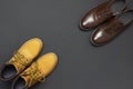 Classic brown leather men`s shoes and Yellow men`s work boots from natural nubuck on gray black background top view flat lay cop Royalty Free Stock Photo