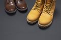 Classic brown leather men`s shoes and Yellow men`s work boots from natural nubuck on gray black background top view flat lay cop Royalty Free Stock Photo