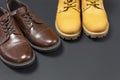 Classic brown leather men`s shoes and Yellow men`s work boots from natural nubuck on gray black background top view flat lay cop Royalty Free Stock Photo