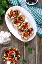 Classic bruschetta with tomatoes and feta on a white plate on a wooden background. Italian sandwiches with toasted baguette, goat Royalty Free Stock Photo