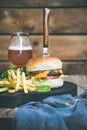 Classic burger dinner with glass of beer and french fries