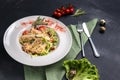 Classic Caesar salad with grilled chicken breast and half of quail eggs in white ceramic plate. Green tablecloth, spoon and fork Royalty Free Stock Photo