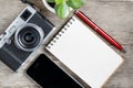 Classic camera with blank notepad page and red pen on gray wooden, vintage desk with telephone