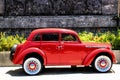 Classic car with bright red color parked in front of old building in Solo, Central Java, Indonesia Royalty Free Stock Photo