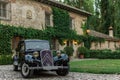 Classic car parked in front of a mansion