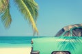 Classic car on a tropical beach with palm tree Royalty Free Stock Photo