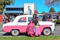 Classic car, woman, and girl, all in bright pink