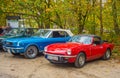Classic cars MG Spitfire and Ford Mustang parked under autumn trees Royalty Free Stock Photo
