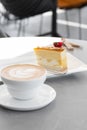 Classic cheesecake with fresh strawberry with cup of coffee on white table. Close Up view. Tasty breakfast. Piece of Royalty Free Stock Photo