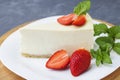 Classic cheesecake New York sliced Piece of cheesecake with fresh strawberries and mint on a white plate on a classic blue Royalty Free Stock Photo