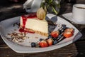 Classic cheesecake with raspberry jam on a plate decorated with fresh strawberries and cup of coffee Royalty Free Stock Photo