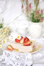 Classic cheesecake with strawberries. On the table in the decor with wildflowers and daisies. bright colors,