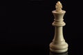 Classic Chess White King on black surface, isolated Royalty Free Stock Photo