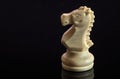 Classic Chess White Knight on black surface, isolated Royalty Free Stock Photo