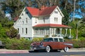 Classic 1957 Chevrolet Bel Air four door sedan parked on on the street in front of eclectic Queen Anne architecture style historic