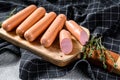 Classic chicken sausages on a cutting Board with rosemary and spices. Black background. Top view