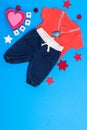 Classic children`s clothing on a blue background. Baby clothes collage. The boy is wearing a red shirt and jeans. pacifier and to