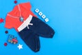 Classic children`s clothing on a blue background. Baby clothes collage. The boy is wearing a red shirt and jeans. pacifier and to