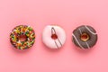 Classic chocolate, strawberry, decorated with colorful sprinkles donut isolated on pink background Flat lat lay Top View Knolling