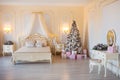 Classic Christmas decorated interior room with New year tree. Modern luxury design apartment bedroom with bed. Christmas Royalty Free Stock Photo