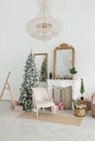 Classic Christmas interior with decorated Christmas tree. Fireplace with armchair, mirror on the wall Royalty Free Stock Photo