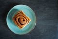 classic cinnamon roll on an artisan plate in the kitchen top view Royalty Free Stock Photo