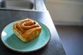 classic cinnamon roll on an artisan plate in the kitchen top view Royalty Free Stock Photo