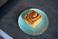 classic cinnamon roll on an artisan plate in the kitchen top view Royalty Free Stock Photo