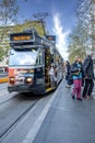 Classic city tram stopped at station along Swanston Street