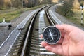 Classic compass in hand on the background of the railway