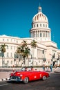 Classic convertible car next to the iconic Capitol building in Havana