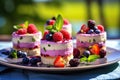 classic cream cheese dessert: mini cheesecakes decorated with strawberries, blueberries, raspberries and blackberries with mint