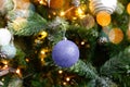 Classic decorated Christmas tree with ornaments ball colored in trendy color of year 2022 Very Peri background. Inspired
