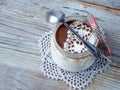 Classic delicious italian cheese dessert Tiramisu in glass jar on light wooden background.