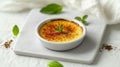 A classic dessert, creme brulee, elegantly presented on a white surface