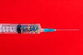 A classic disposable syringe filled with symbolic hearts. Love concept. Background with copy space. Red backdrop